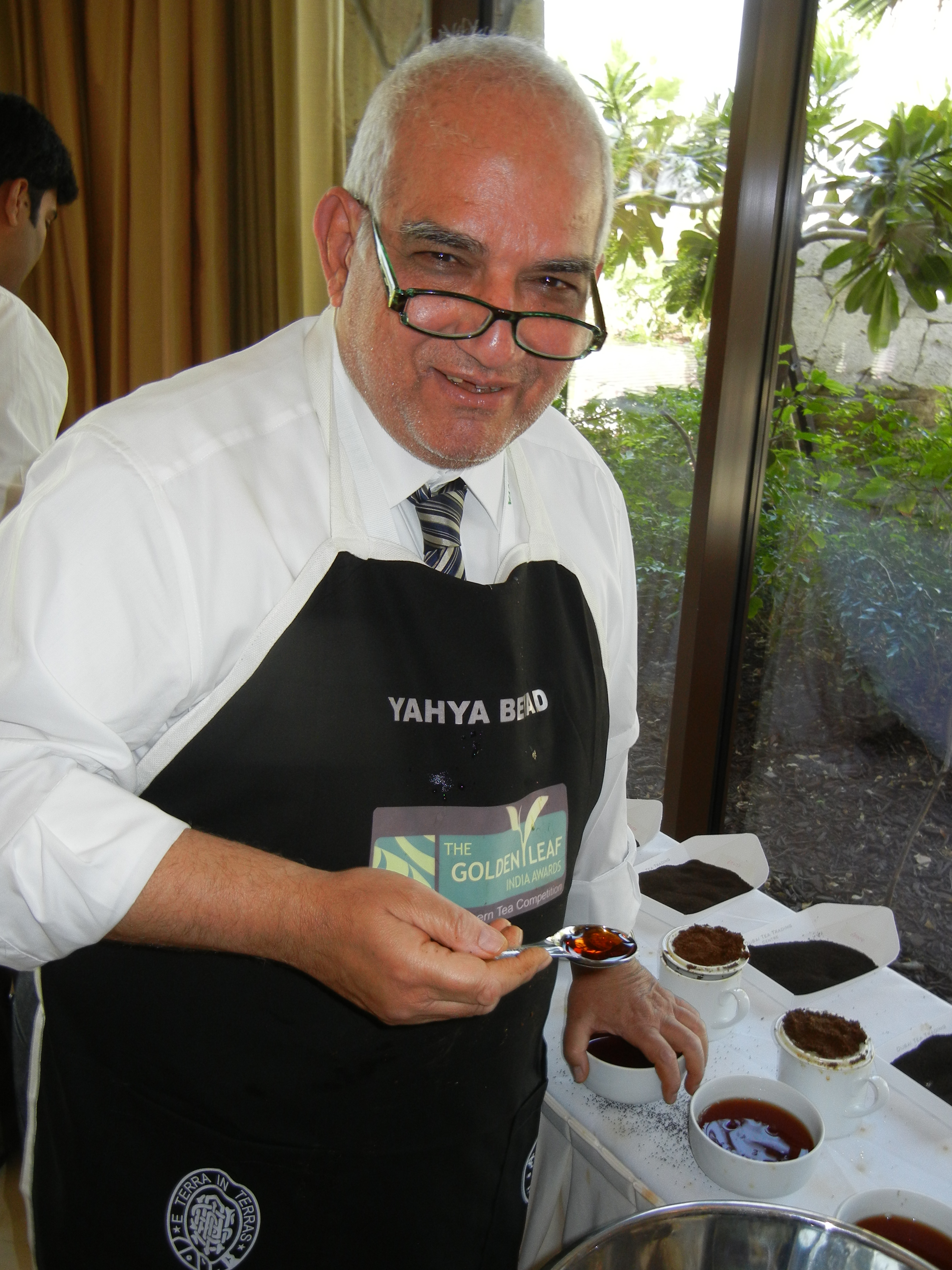 Golden Leaf India Judge Yahya Beyad, owner of Britannia Teas stands over the spittoon.